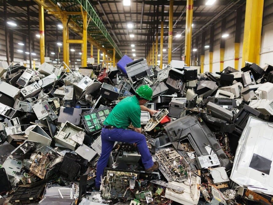 Worker sorting e-waste at a recycling facility